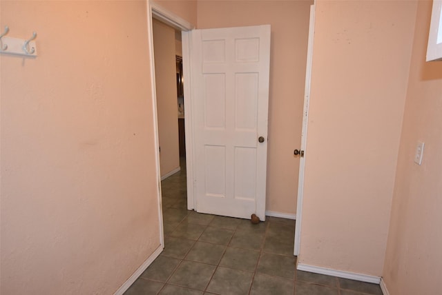 hallway with dark tile patterned floors