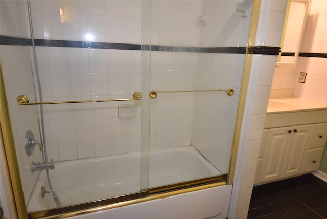 bathroom featuring tile patterned floors, vanity, and enclosed tub / shower combo