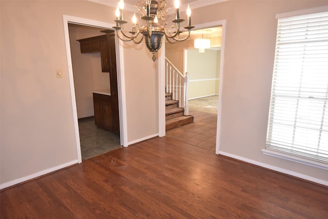 unfurnished dining area with dark hardwood / wood-style flooring and an inviting chandelier