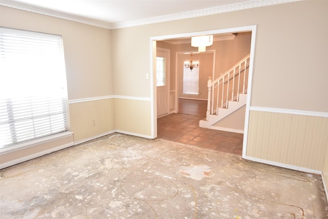 empty room featuring a notable chandelier and ornamental molding