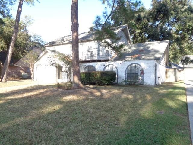 view of front of home with a balcony and a front lawn