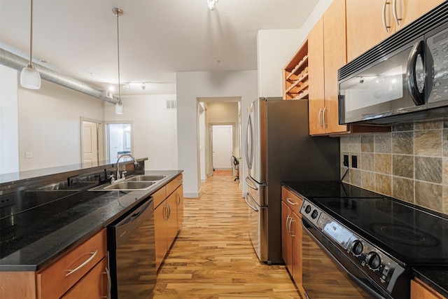 kitchen with decorative backsplash, sink, black appliances, decorative light fixtures, and light hardwood / wood-style floors