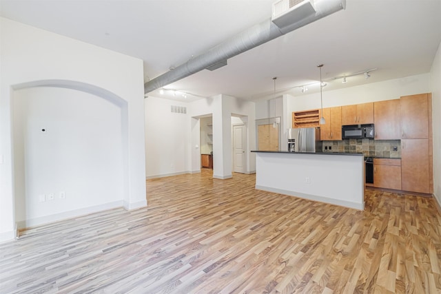 kitchen featuring tasteful backsplash, stainless steel fridge with ice dispenser, hanging light fixtures, and light wood-type flooring