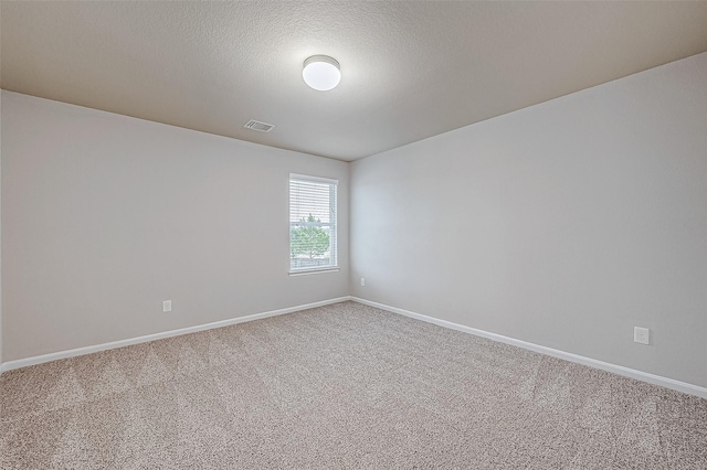 carpeted spare room featuring a textured ceiling