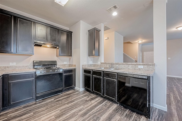 kitchen with a textured ceiling, sink, dark wood-type flooring, and black appliances