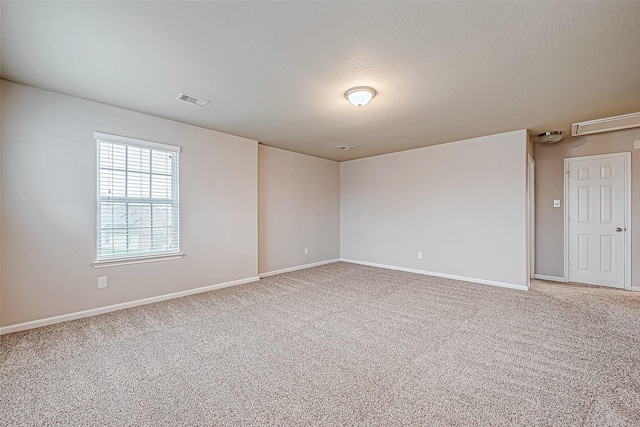 empty room with carpet floors and a textured ceiling