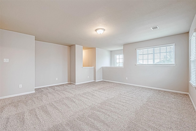 empty room with carpet floors and a textured ceiling