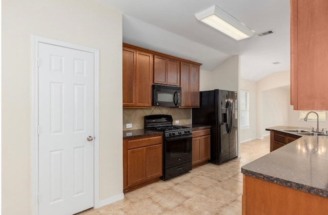 kitchen featuring black appliances, sink, vaulted ceiling, decorative backsplash, and light tile patterned flooring