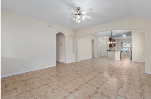 spare room with ceiling fan with notable chandelier