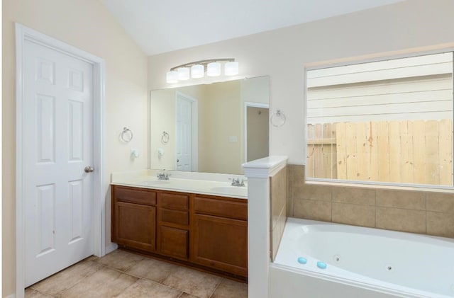 bathroom with a washtub, vanity, tile patterned floors, and lofted ceiling