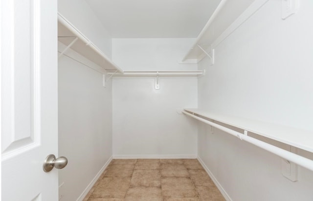 spacious closet with light tile patterned floors