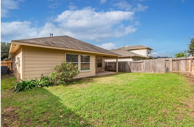 rear view of house featuring a patio area, central air condition unit, and a yard