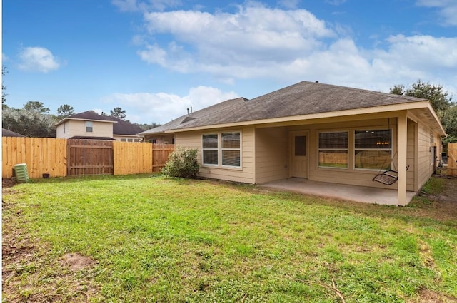 rear view of house featuring a yard and a patio