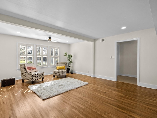 living area with ceiling fan and hardwood / wood-style floors