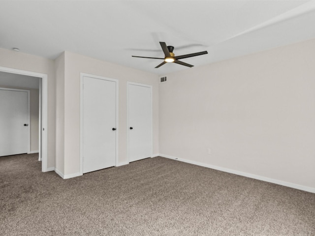 unfurnished bedroom featuring carpet floors, two closets, and ceiling fan