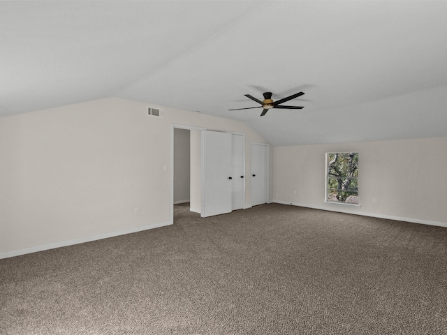 additional living space featuring dark carpet, ceiling fan, and lofted ceiling