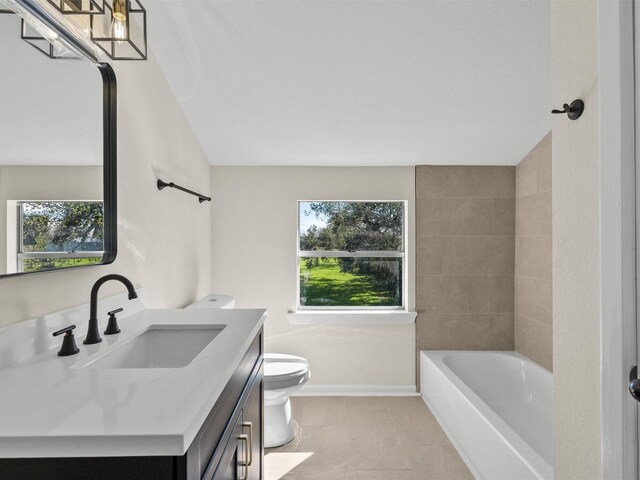 full bathroom with tile patterned floors, vanity, tiled shower / bath combo, and toilet