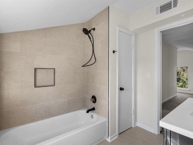 bathroom with vanity, tile patterned floors, tiled shower / bath, and lofted ceiling