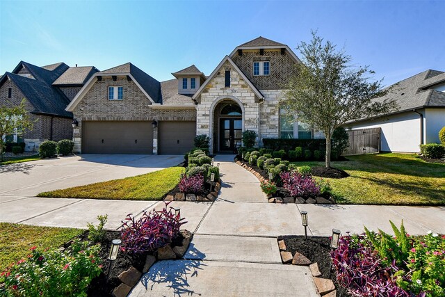 view of front of house with a front yard, french doors, and a garage