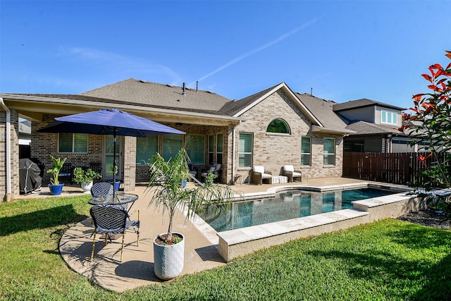 back of property with a patio area and a lawn