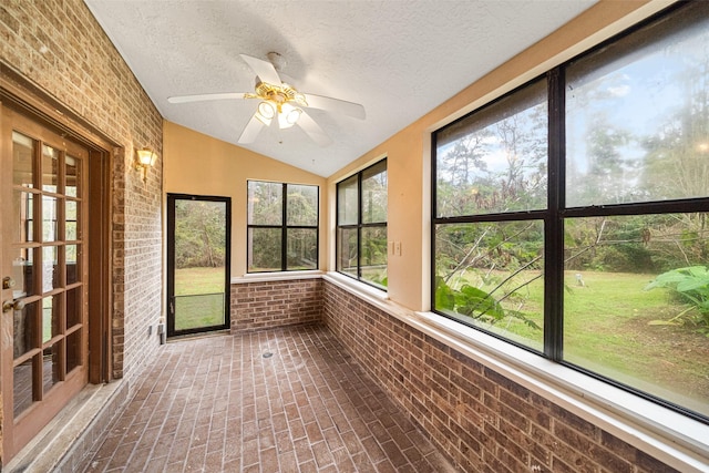 unfurnished sunroom with ceiling fan and vaulted ceiling