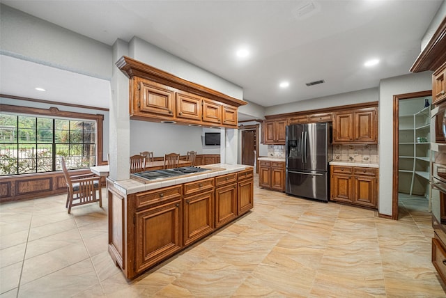 kitchen with decorative backsplash, stainless steel appliances, and tile countertops