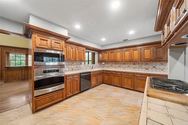 kitchen with backsplash, stainless steel appliances, light hardwood / wood-style floors, and sink