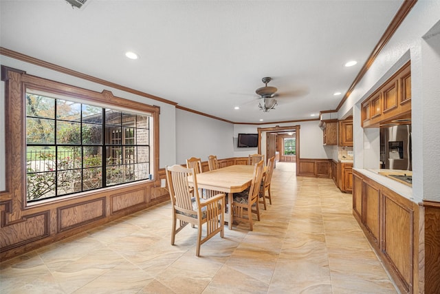 dining space with ceiling fan and ornamental molding