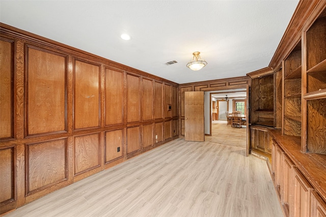 unfurnished living room featuring wood walls and light hardwood / wood-style flooring