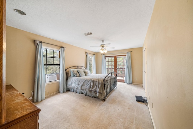 carpeted bedroom featuring multiple windows, ceiling fan, french doors, and a textured ceiling