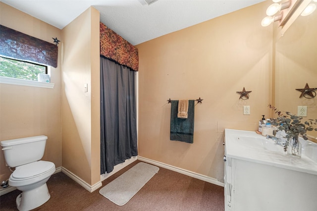 bathroom featuring a textured ceiling, vanity, and toilet