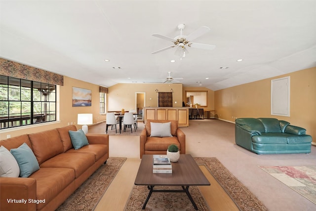 living room with light wood-type flooring, vaulted ceiling, and ceiling fan