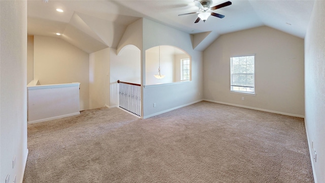 interior space featuring ceiling fan, light colored carpet, and lofted ceiling