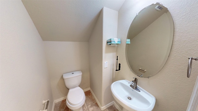 bathroom featuring tile patterned floors, toilet, sink, and vaulted ceiling