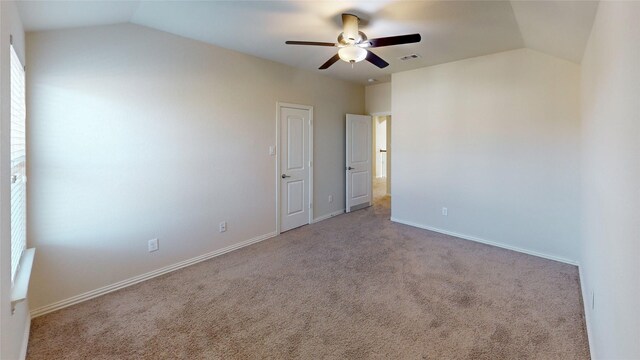 empty room featuring light carpet, ceiling fan, and vaulted ceiling