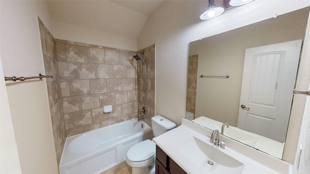 full bathroom featuring vanity, toilet, lofted ceiling, and tiled shower / bath