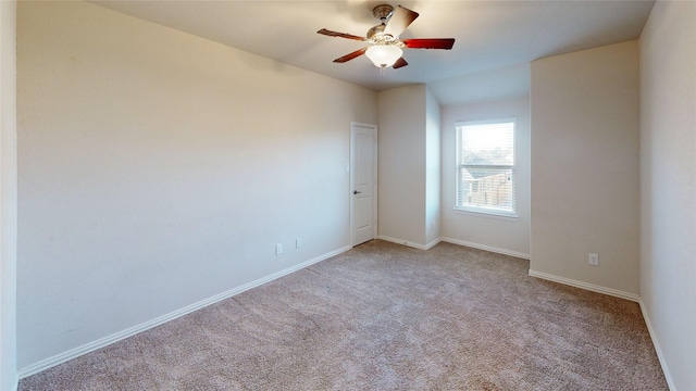 carpeted spare room with ceiling fan