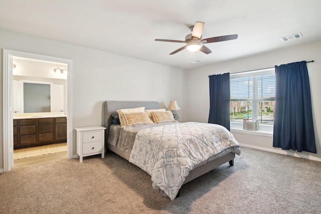 bedroom with ceiling fan, carpet floors, and ensuite bath