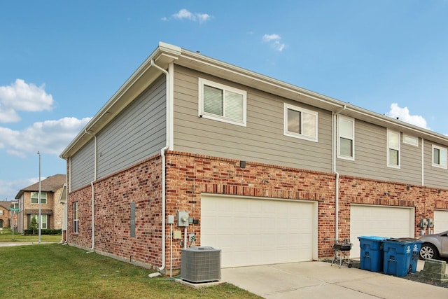 view of property exterior featuring a yard, cooling unit, and a garage