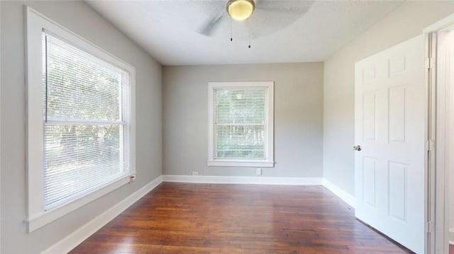 spare room featuring dark hardwood / wood-style flooring and ceiling fan