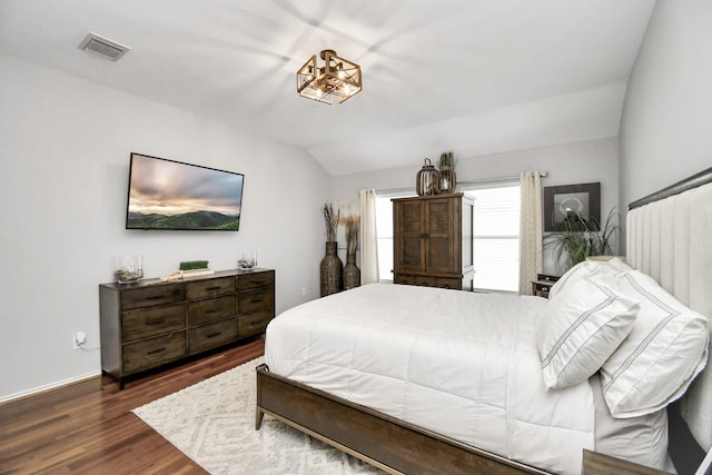 bedroom with dark wood-type flooring and lofted ceiling