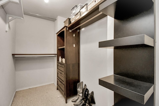 walk in closet featuring light colored carpet