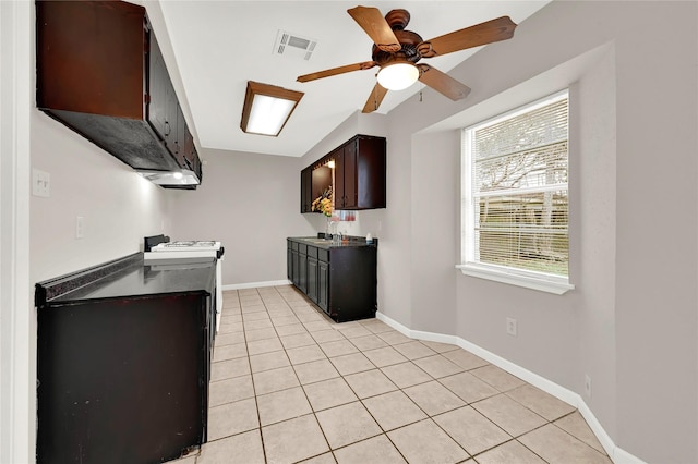 kitchen with light tile patterned flooring, sink, white stove, dark brown cabinets, and ceiling fan