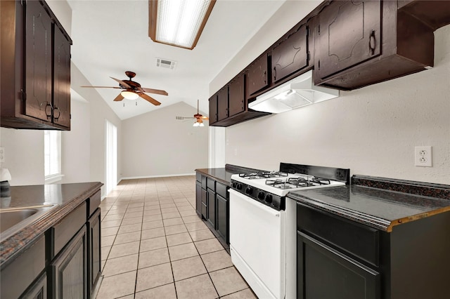 kitchen with vaulted ceiling, light tile patterned flooring, white gas range, ceiling fan, and dark brown cabinets