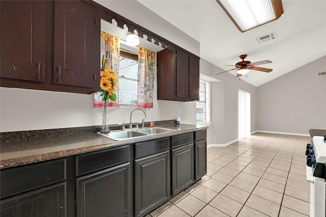 kitchen featuring light tile patterned flooring, lofted ceiling, sink, dark brown cabinets, and ceiling fan