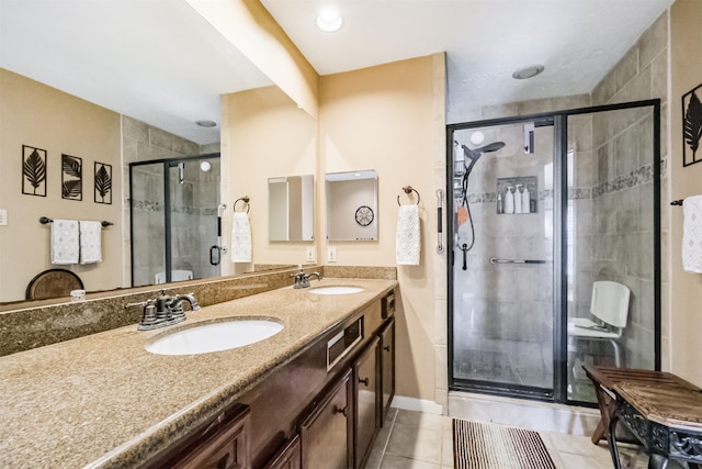 bathroom with tile patterned flooring, vanity, and a shower with door