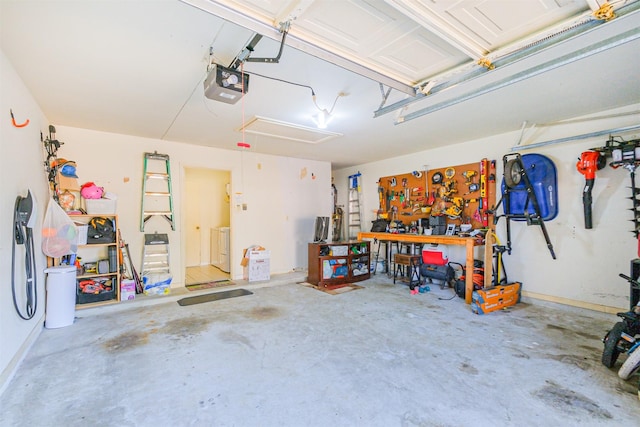 garage featuring a workshop area, washer and clothes dryer, and a garage door opener