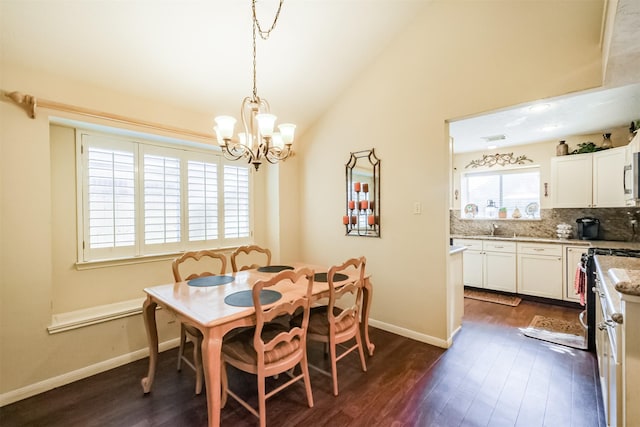 dining area featuring sink, dark wood-type flooring, high vaulted ceiling, and a chandelier