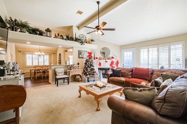 carpeted living room featuring ceiling fan with notable chandelier and lofted ceiling with beams