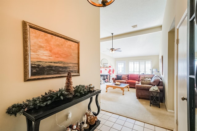 carpeted living room with ceiling fan and vaulted ceiling